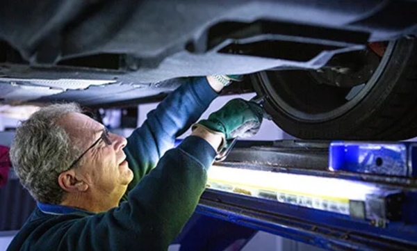 Mechanic inspecting underneath a car